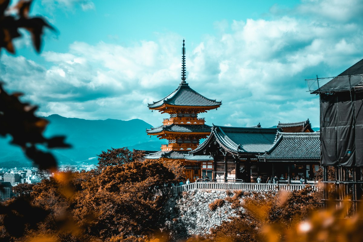 A traditional pagoda with people walking nearby under a blue sky in Japan