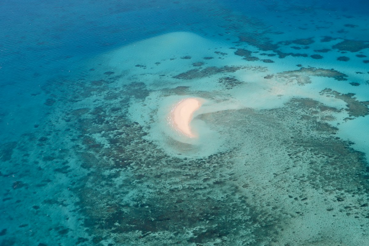 A turquoise sandbar surrounded by coral reef near Australia