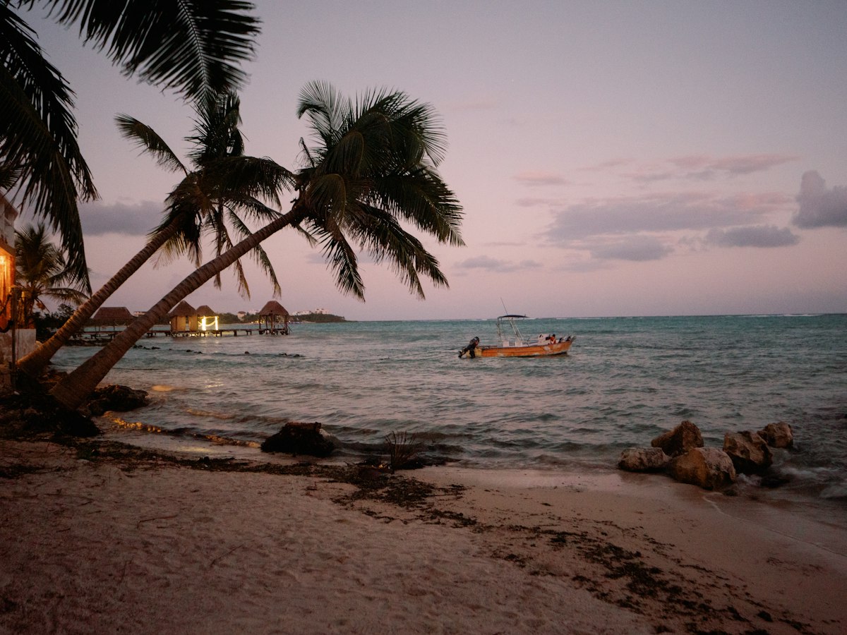 A wooden boat on the water near a Mexican coastal beach